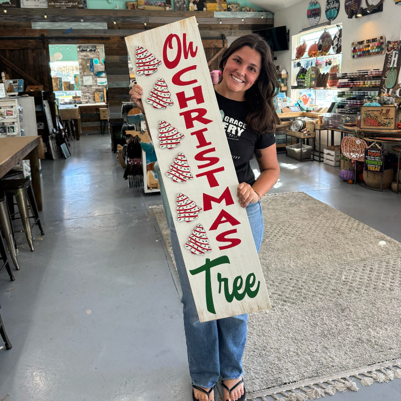Person holding a Christmas-themed sign in a store