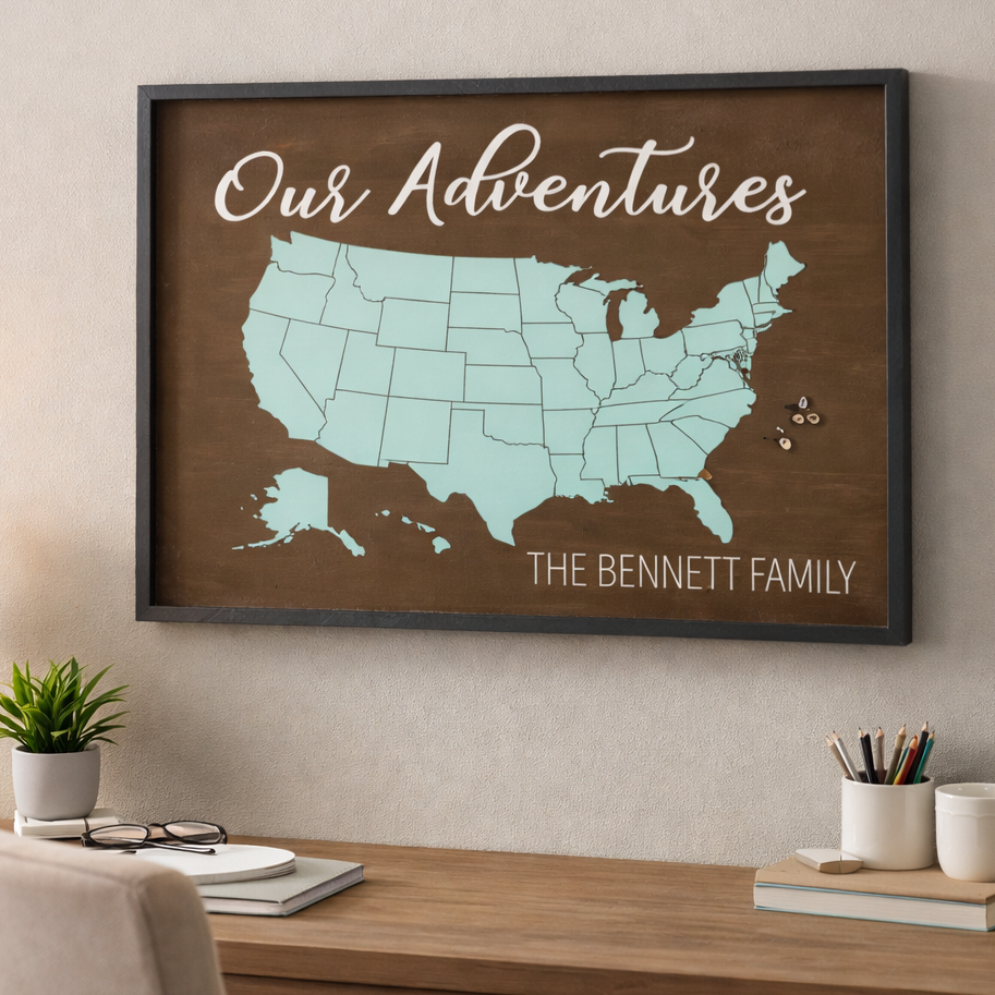 Framed map of the United States with 'Our Adventures' text on a wall above a desk.