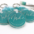 Turquoise keychains with 'Make' and 'Pauley Grace Maker' text on a white background