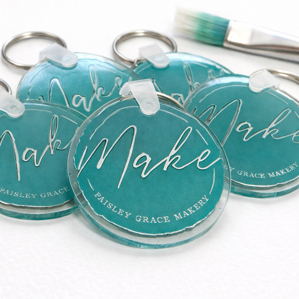 Turquoise keychains with 'Make' and 'Pauley Grace Maker' text on a white background