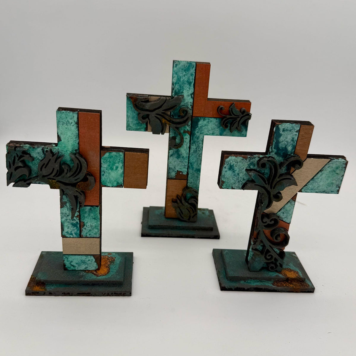 Three decorative crosses with intricate designs on a white background