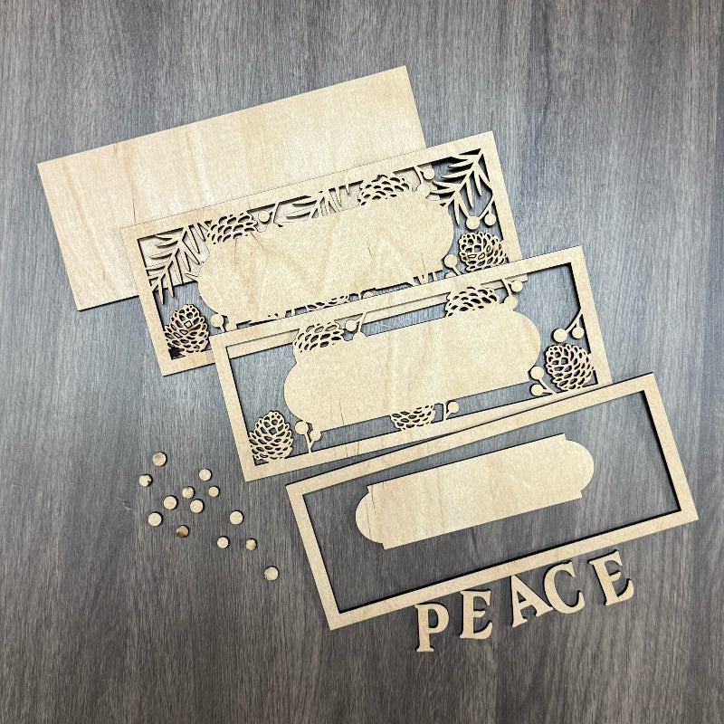 Wooden cutouts with decorative patterns and 'PEACE' text on a wooden surface