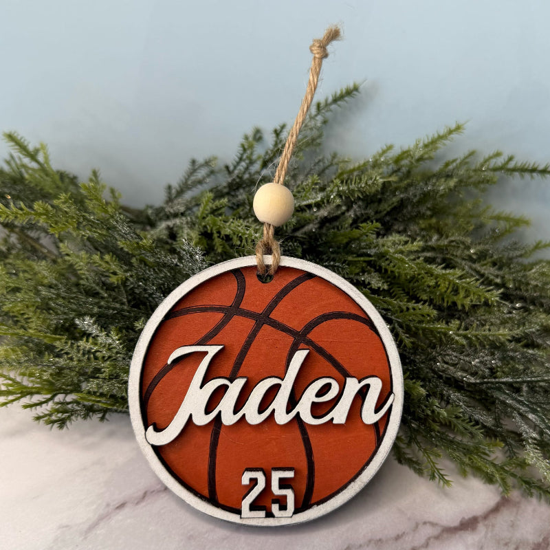 Basketball-themed ornament with 'Jaden' and number '25' hanging on a branch.