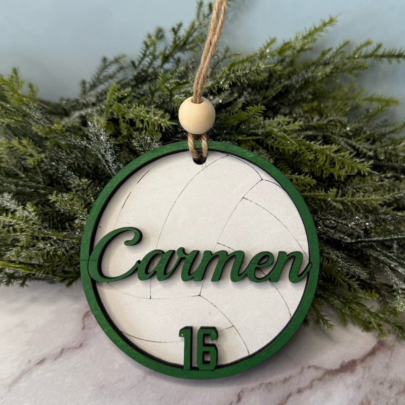 Decorative ornament with 'Carmen' and number '16' on a marble surface with greenery.