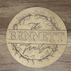 Wooden circular sign with 'The Bennett Family' engraving on a wooden background