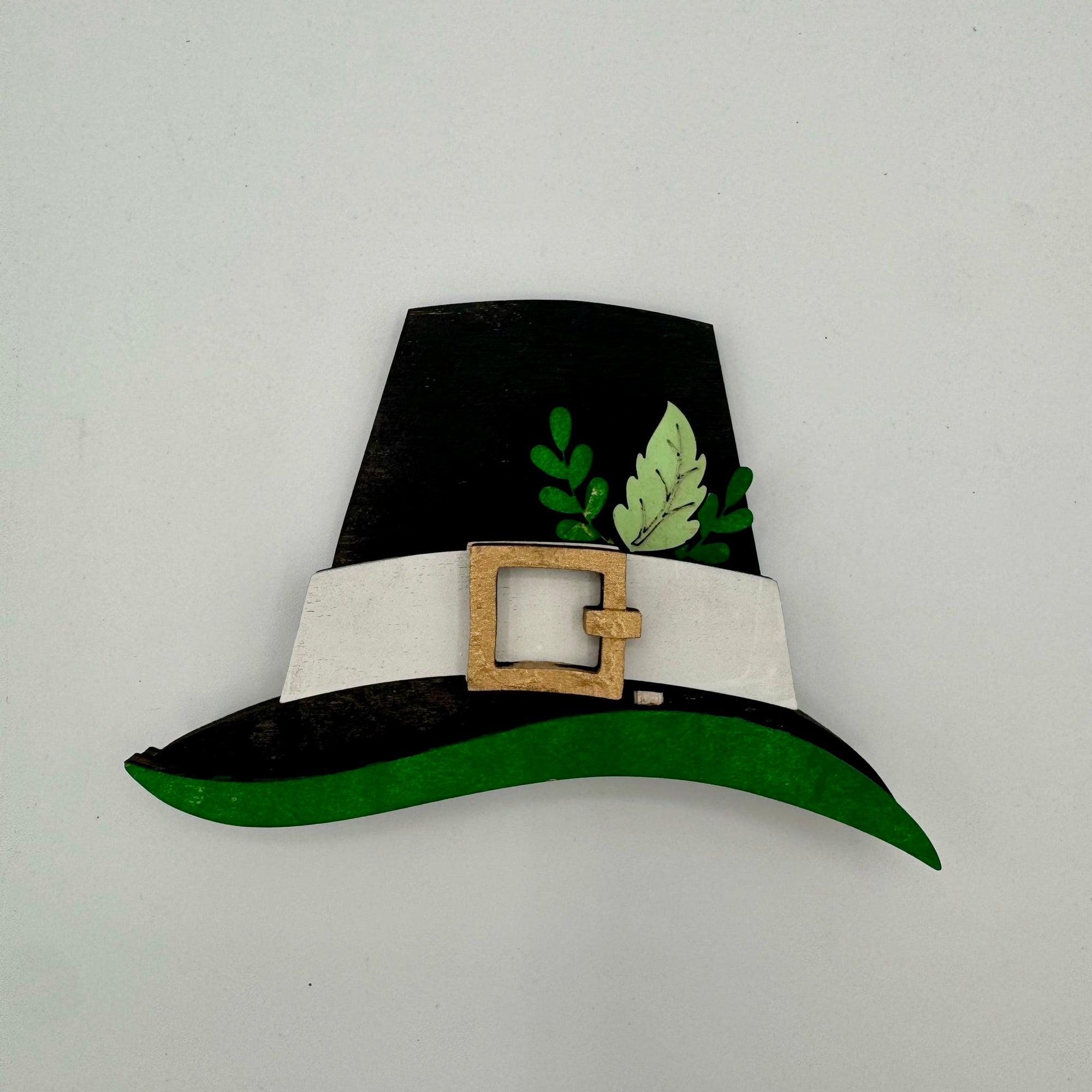 Black and green hat with a white band and gold buckle on a light gray background