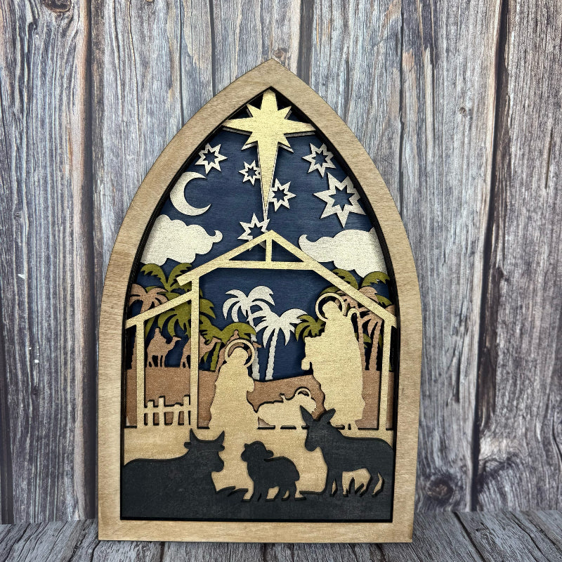 Wooden nativity scene cutout against a wooden background