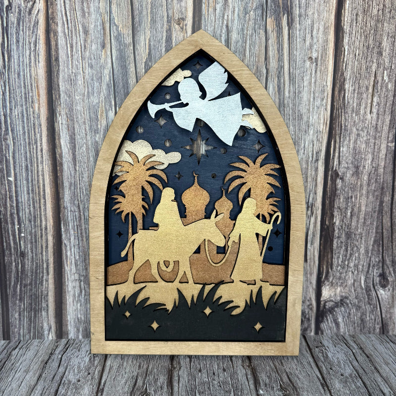 Wooden nativity scene cutout with an angel on a wooden background