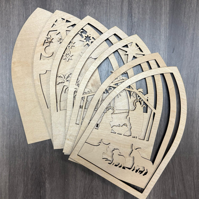 Set of wooden cut-out shapes with geometric and nature-themed designs on a wooden surface.