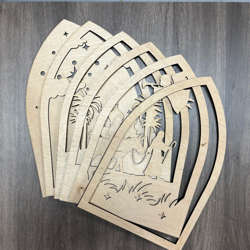Set of wooden nativity scene cutouts on a wooden surface