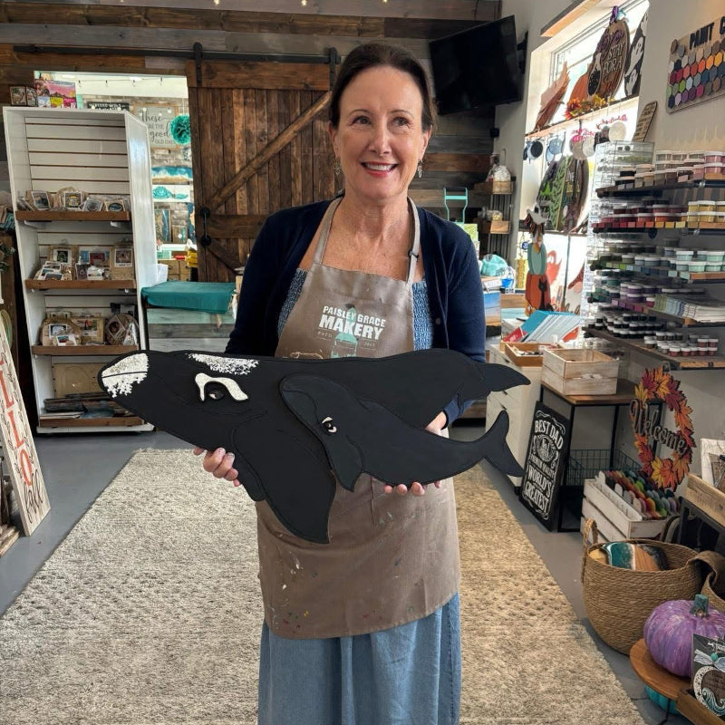 Woman holding a large black bird sculpture in a store setting