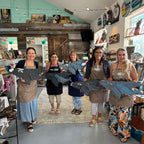 Five women in a store holding fabric samples