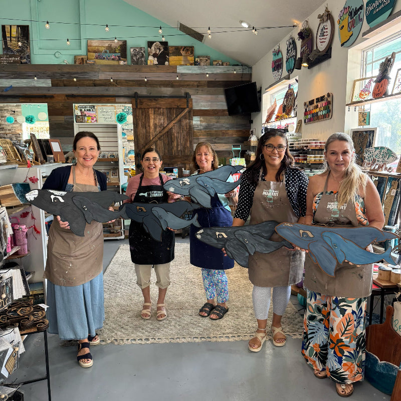 Five women in a store holding fabric samples