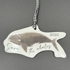 Whale-shaped ornament with 'Save the Whales' text on a gray background