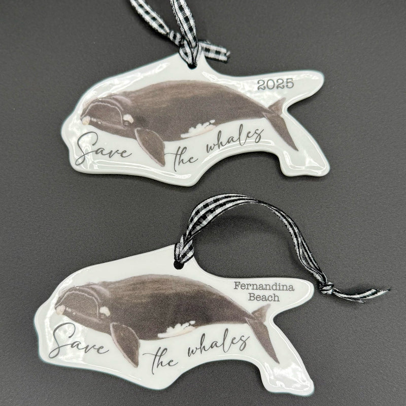 Two whale-shaped ornaments with 'Save the Whales' text on a dark background