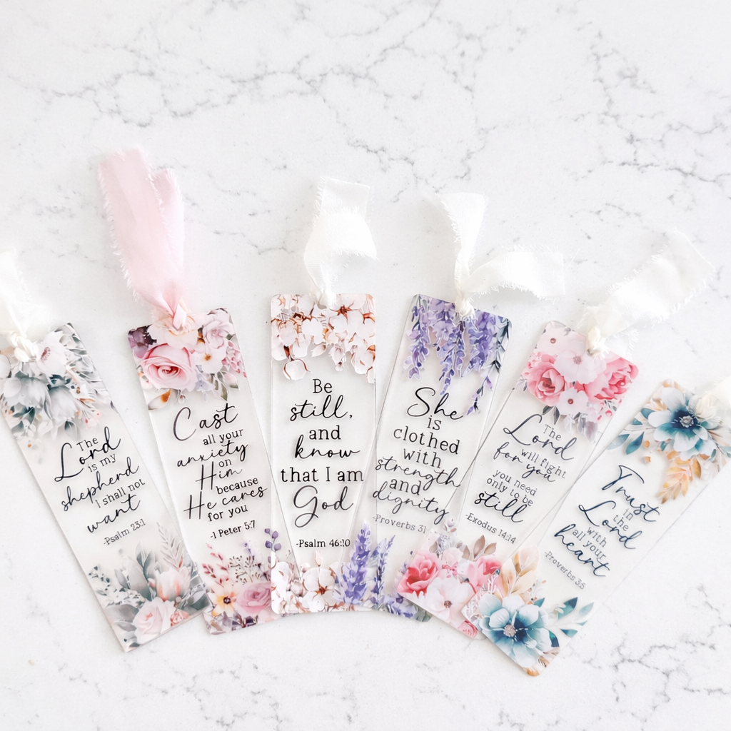 Set of floral bookmarks with inspirational quotes on a textured white surface