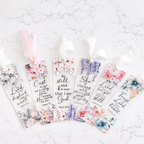 Set of floral bookmarks with inspirational quotes on a textured white surface