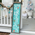 Decorative sign with 'Seas & Greetings' on a porch with Christmas decorations. Fernandina Beach DIY Craft Party.