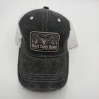 A dark gray washed trucker hat with a black and white Shark Tooth Hunter patch on the front, set against a plain light gray background.