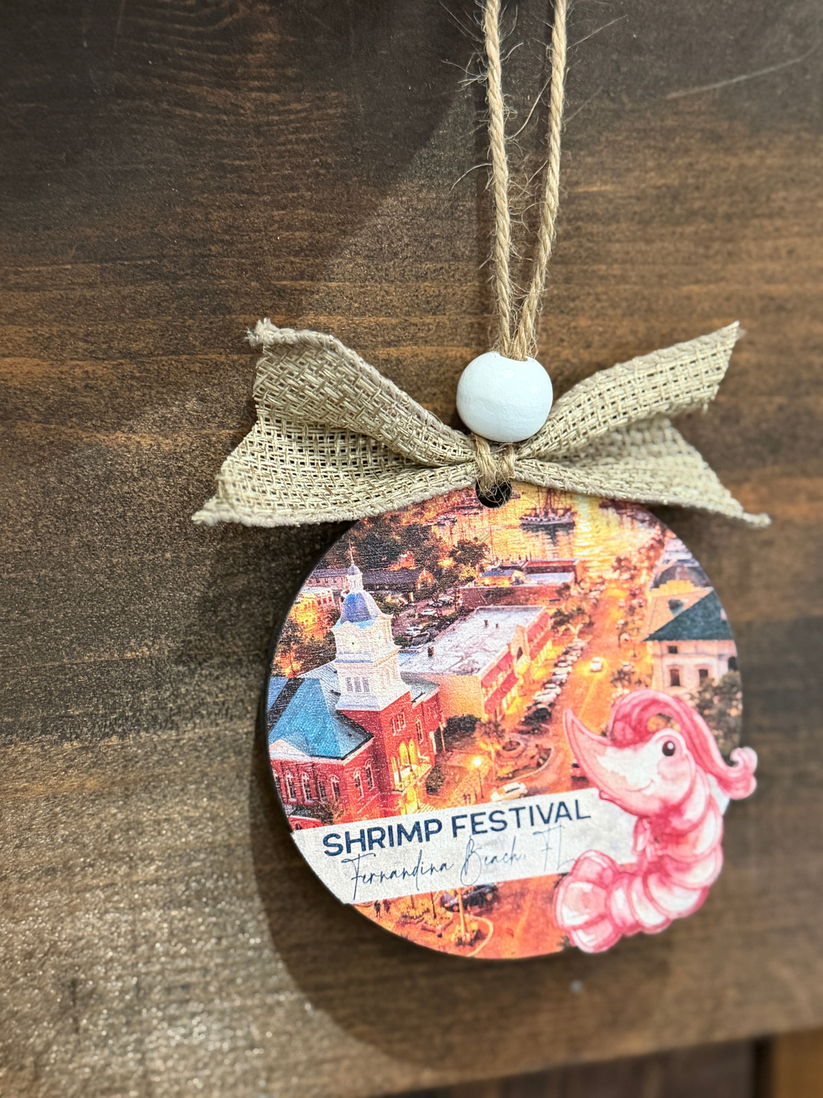 Decorative ornament with a shrimp festival design on a wooden surface