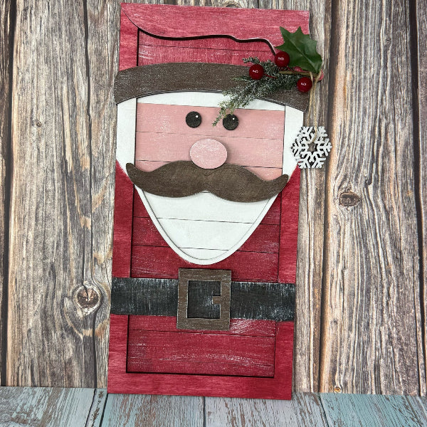 Wooden Santa Claus face decoration on a rustic wooden background