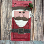 Wooden Santa Claus face decoration on a rustic wooden background
