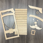 Wooden cutouts of decorative items including a shield, slats, and facial features on a wooden surface.