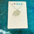 Necklace with football pendant on a card with 'Paisley Grace Design' branding against a teal background.