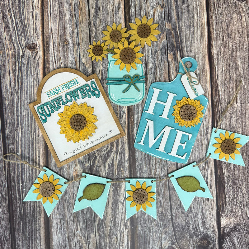 Decorative sunflower-themed items including a sign, jar, and banner on a wooden background.