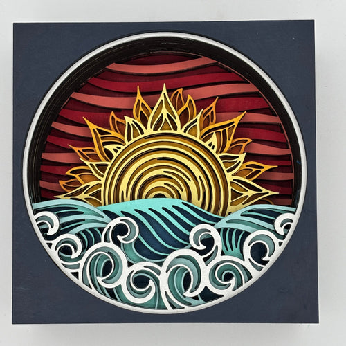 Decorative wall art with a sun and wave design on a dark background