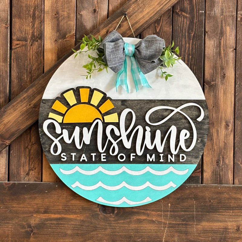Decorative sign with 'Sunshine State of Mind' text on a wooden background