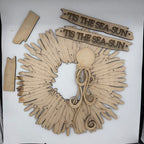 Laser-cut wooden nautical wall decor set featuring a circular sun and moon wreath with an octopus, two banner signs reading 'TIS THE SEA-SUN', and two small rectangular pieces, all shown on a white background.