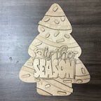 Wooden Christmas tree decoration with 'It's the Season' text on a metallic surface