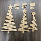 Cardboard Christmas trees and stars on a wooden surface