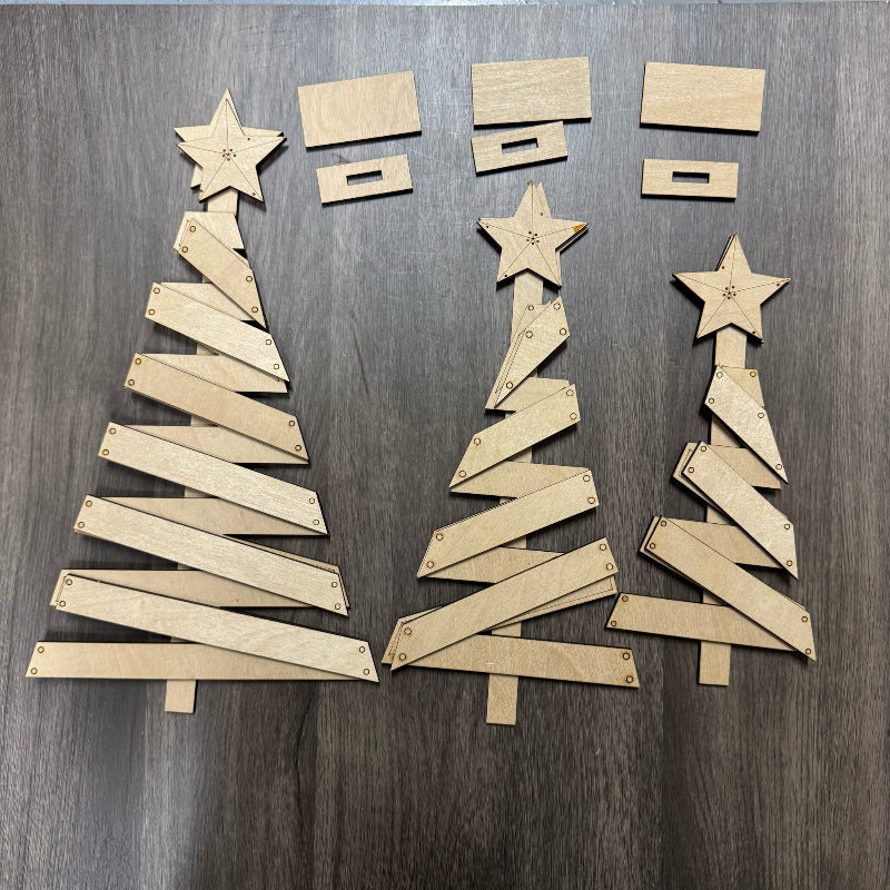 Cardboard Christmas trees and stars on a wooden surface