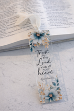 Floral bookmark with 'Trust in the Lord with all your heart' text on a marble surface.