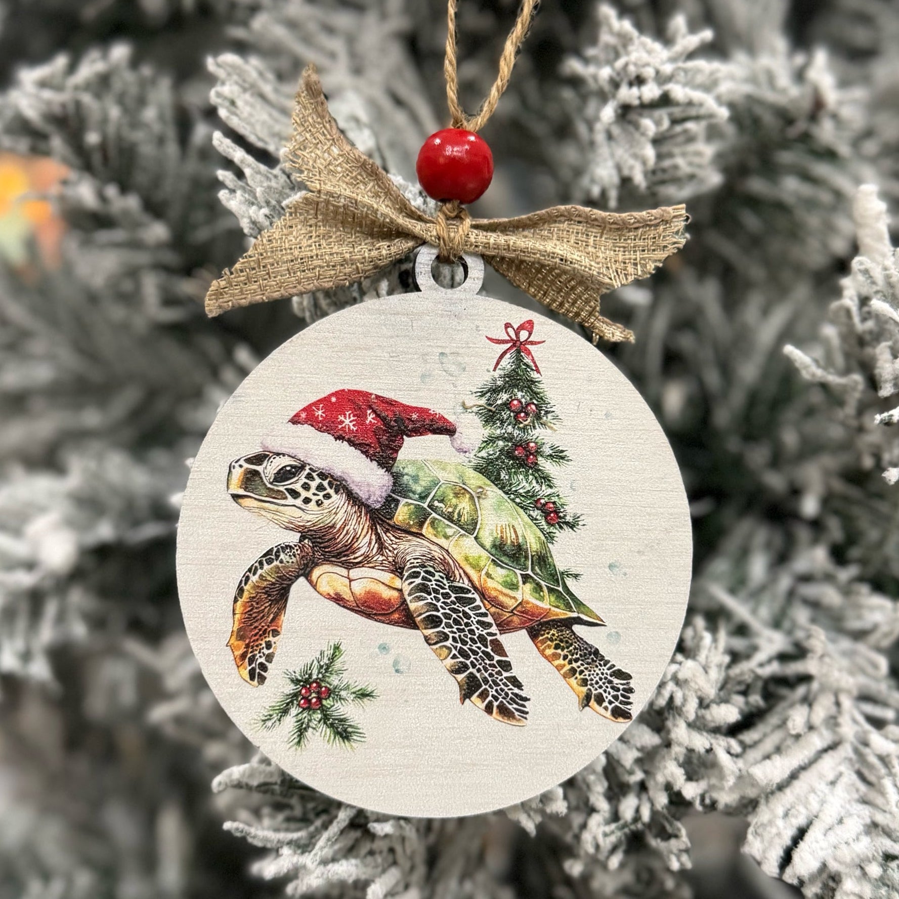 Christmas ornament with a turtle wearing a Santa hat on a tree.
