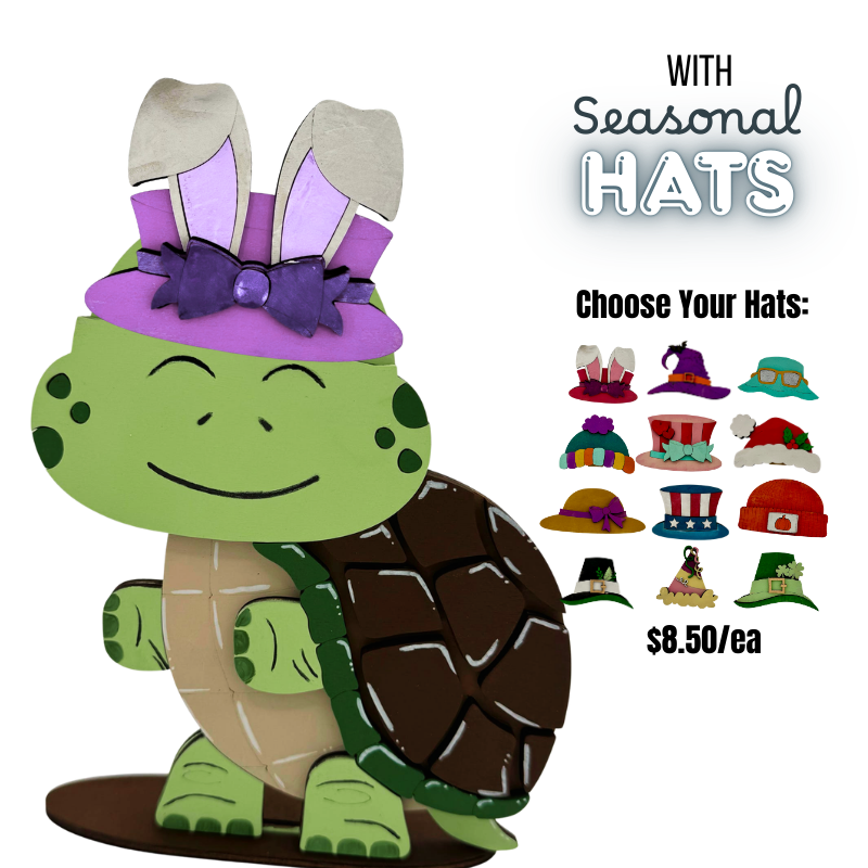 Green turtle figurine with seasonal hats on a white background