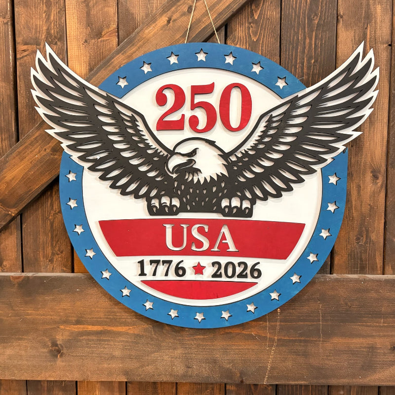 Decorative sign with an eagle and '250 USA 1776-2026' text on a wooden background
