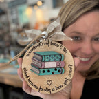 Person holding a wooden ornament with book design and text