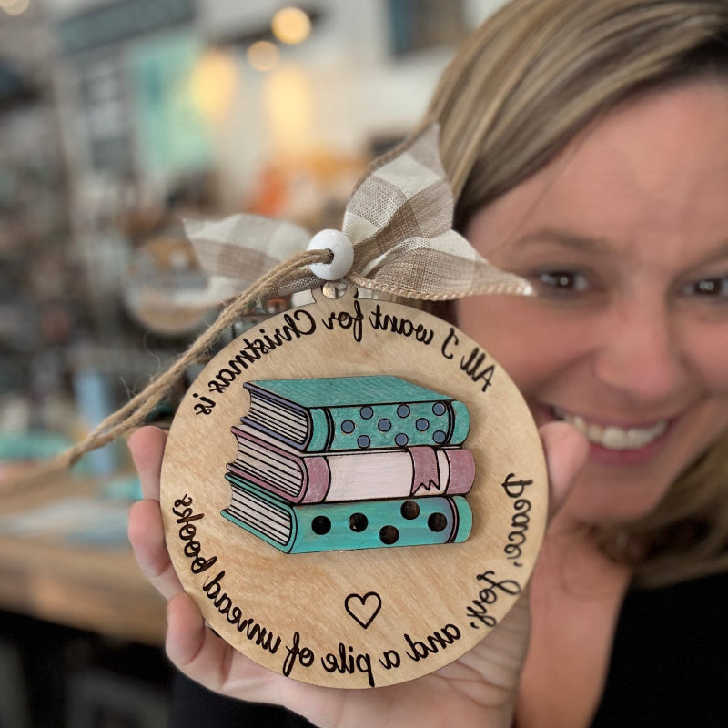 Person holding a wooden ornament with book design and text