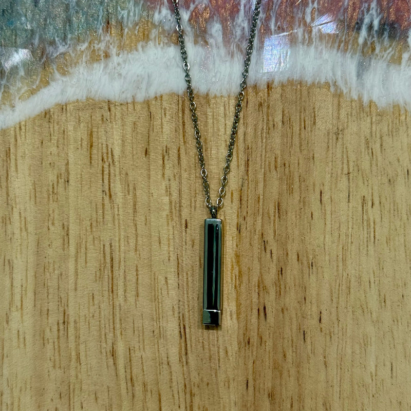 Necklace with a rectangular pendant on a wooden surface