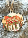 Decorative Christmas ornament with 'Christmas on Amelia Island' text and vintage-style buildings on a textured surface.