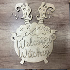 Wooden sign with 'Welcome Witches' text on a wooden background