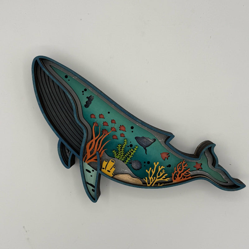 Decorative whale-shaped object with underwater scene design on a white background