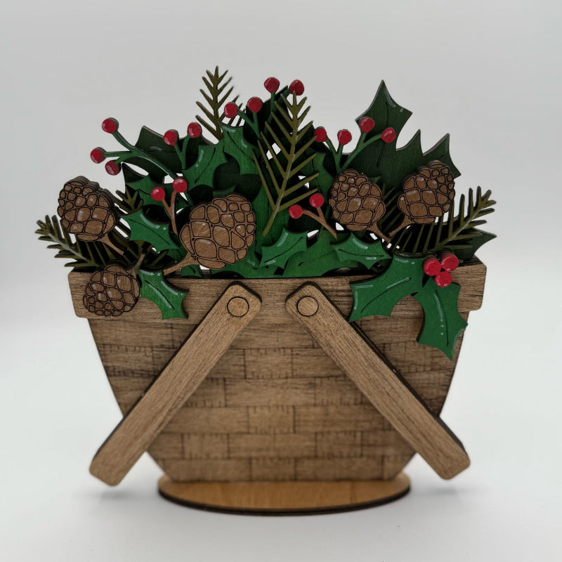 Decorative wooden basket with holly leaves, pine cones, and berries on a white background
