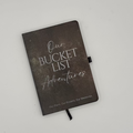 Journal titled 'Our Bucket List Adventures' on a light gray background