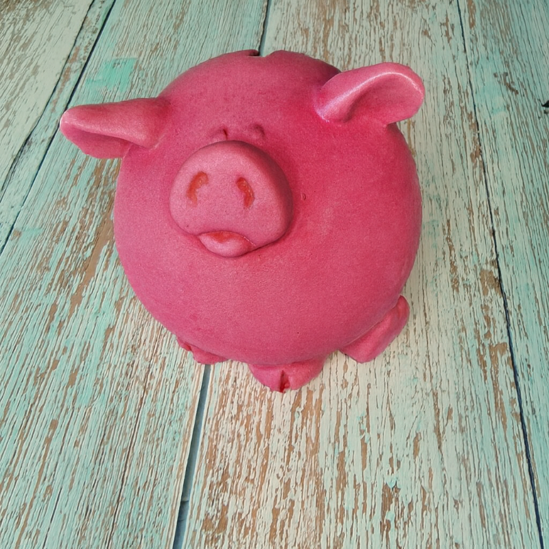 Pink pig-shaped object on a wooden surface