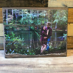 Engagement photo of a couple beside a pond on a three plank wood photo pallet