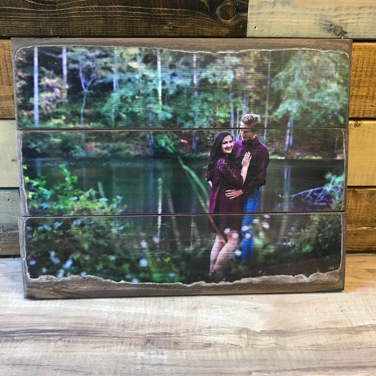 Engagement photo of a couple beside a pond on a three plank wood photo pallet
